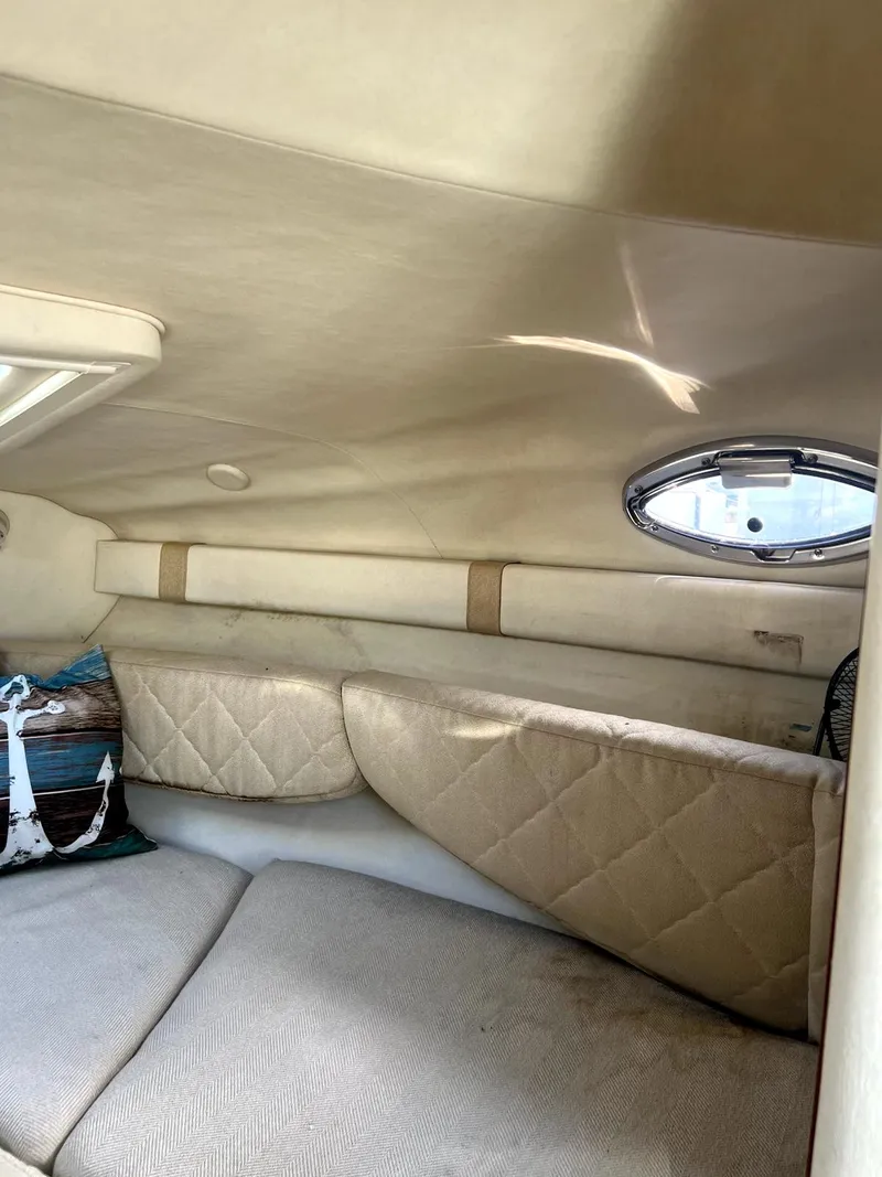 Slide: The Image of Interior of 2005 Sea Ray Sundancer boat with beige upholstery and round window. - 7