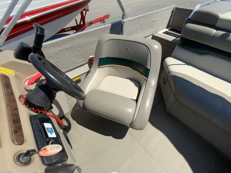 Slide: The Image of 1998 Sun Tracker Party Deck 21 boat interior with steering wheel and seating. - 11