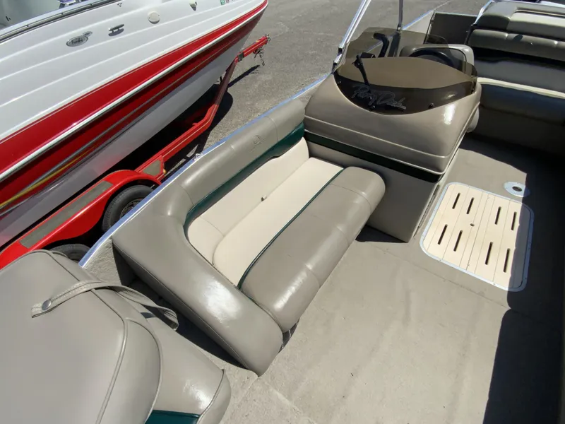 Slide: The Image of 1998 Sun Tracker Party Deck 21 interior with beige seating and steering console. - 4