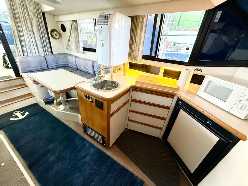 Slide: The Image of Interior of 1992 Carver Command Bridge 2828 with kitchenette and seating area. - 12