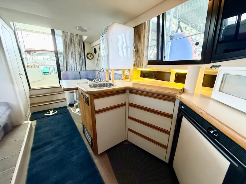 Slide: The Image of Interior of 1992 Carver Command Bridge 2828, featuring kitchen and seating area. - 15