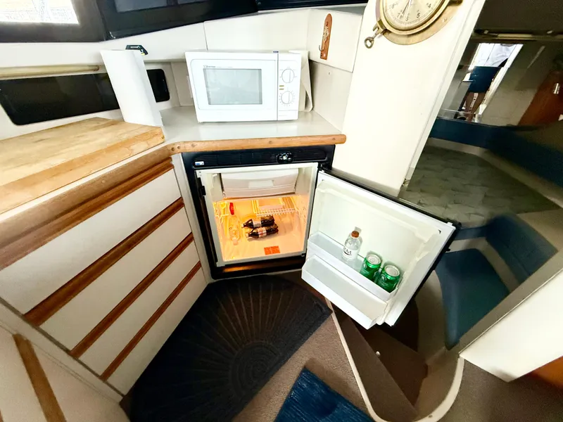 Slide: The Image of 1992 Carver Command Bridge 2828 interior with open mini fridge and microwave. - 18