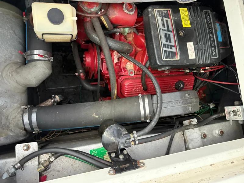 Slide: The Image of Engine compartment of a 1992 Carver Command Bridge 2828 boat, featuring a red engine. - 26