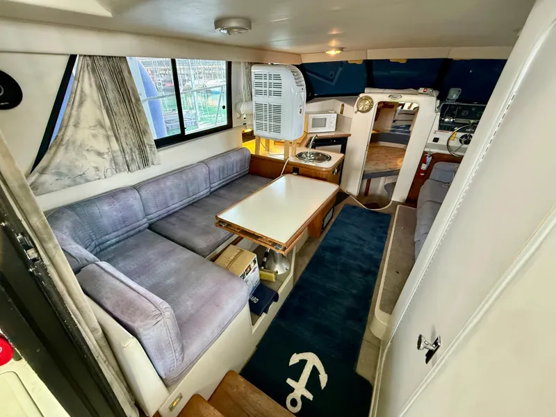 Slide: The Image of Interior of 1992 Carver Command Bridge 2828 with seating, table, and nautical decor. - 7