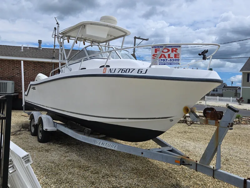 The Image of 1999 Mako 253 Walk Around boat on trailer, for sale sign visible. - 0
