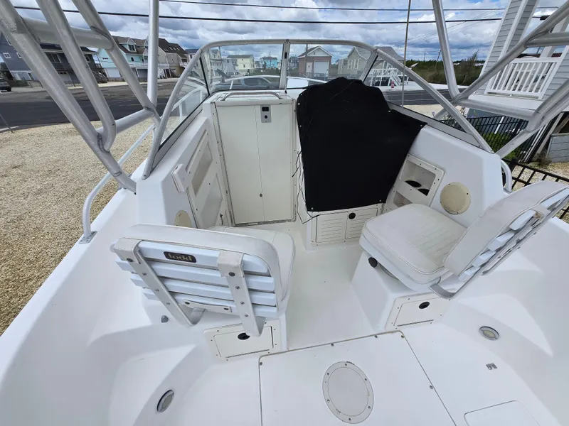 Slide: The Image of 1999 Mako 253 Walk Around boat interior with seating and storage compartments. - 10