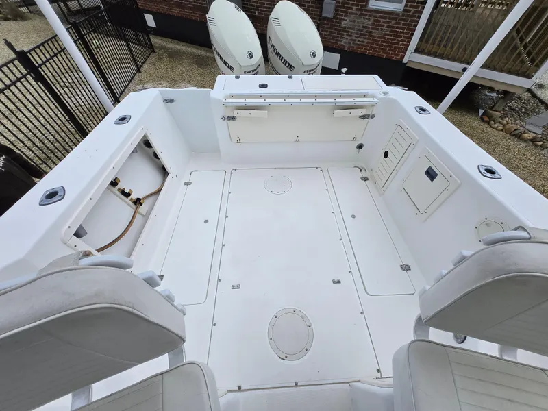 Slide: The Image of 1999 Mako 253 Walk Around boat deck with seating and storage compartments. - 12