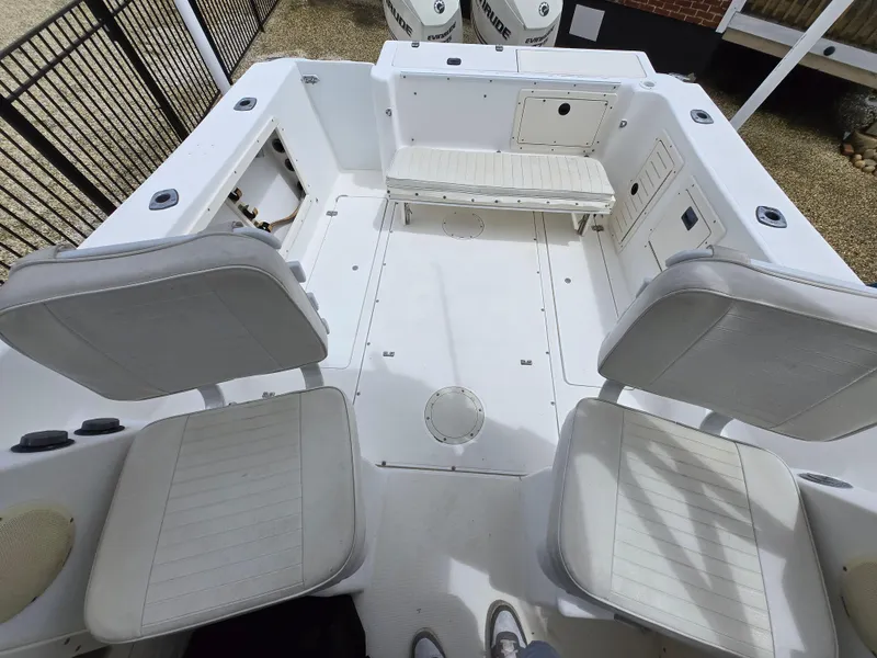 Slide: The Image of 1999 Mako 253 Walk Around boat interior with seating and storage compartments. - 16