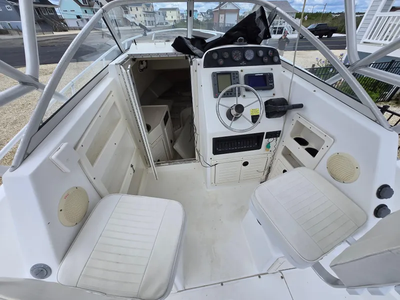 Slide: The Image of 1999 Mako 253 Walk Around boat interior with steering console and seating. - 19
