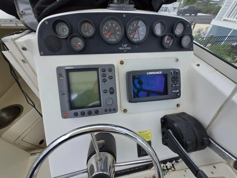 Slide: The Image of 1999 Mako 253 Walk Around boat dashboard with gauges and navigation equipment. - 20