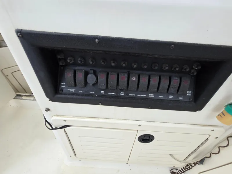 Slide: The Image of Control panel of a 1999 Mako 253 Walk Around boat with multiple switches. - 22
