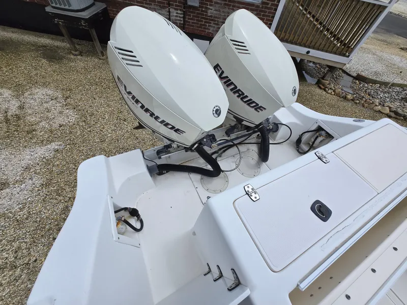 Slide: The Image of 1999 Mako 253 Walk Around boat with dual Evinrude outboard motors. - 25