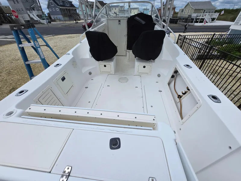 Slide: The Image of 1999 Mako 253 Walk Around boat interior with seating and storage compartments. - 26