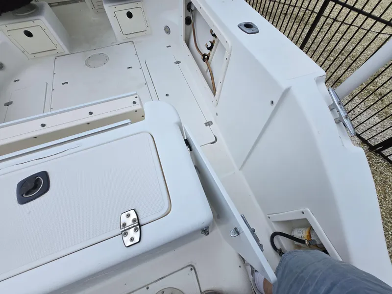 Slide: The Image of 1999 Mako 253 Walk Around boat interior with storage compartments and seating area. - 27