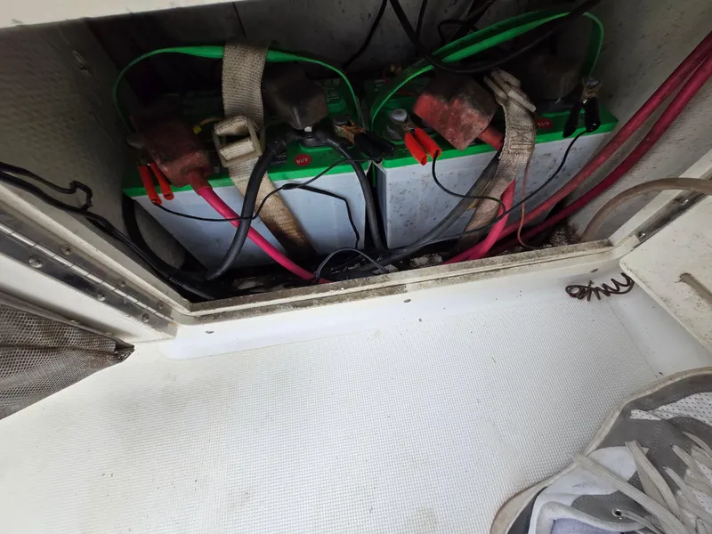 Slide: The Image of Battery compartment of a 1999 Mako 253 Walk Around boat with visible wiring. - 28