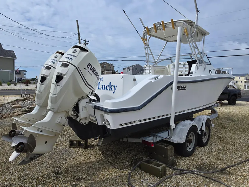Slide: The Image of 1999 Mako 253 Walk Around boat on trailer with dual Evinrude engines. - 3