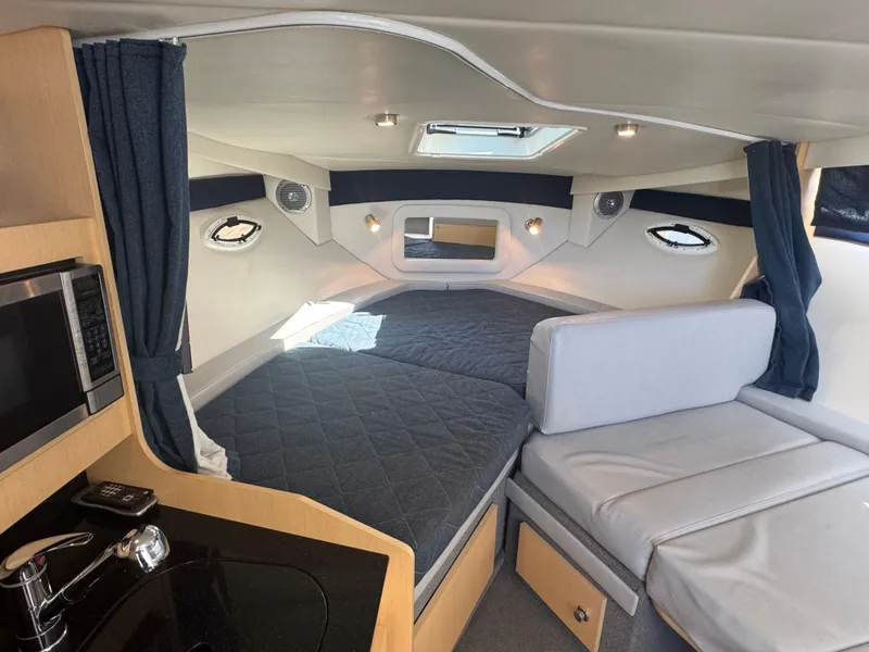 Slide: The Image of Interior of 2011 Bayliner 285 Cruiser with bed, seating, and kitchenette. - 12