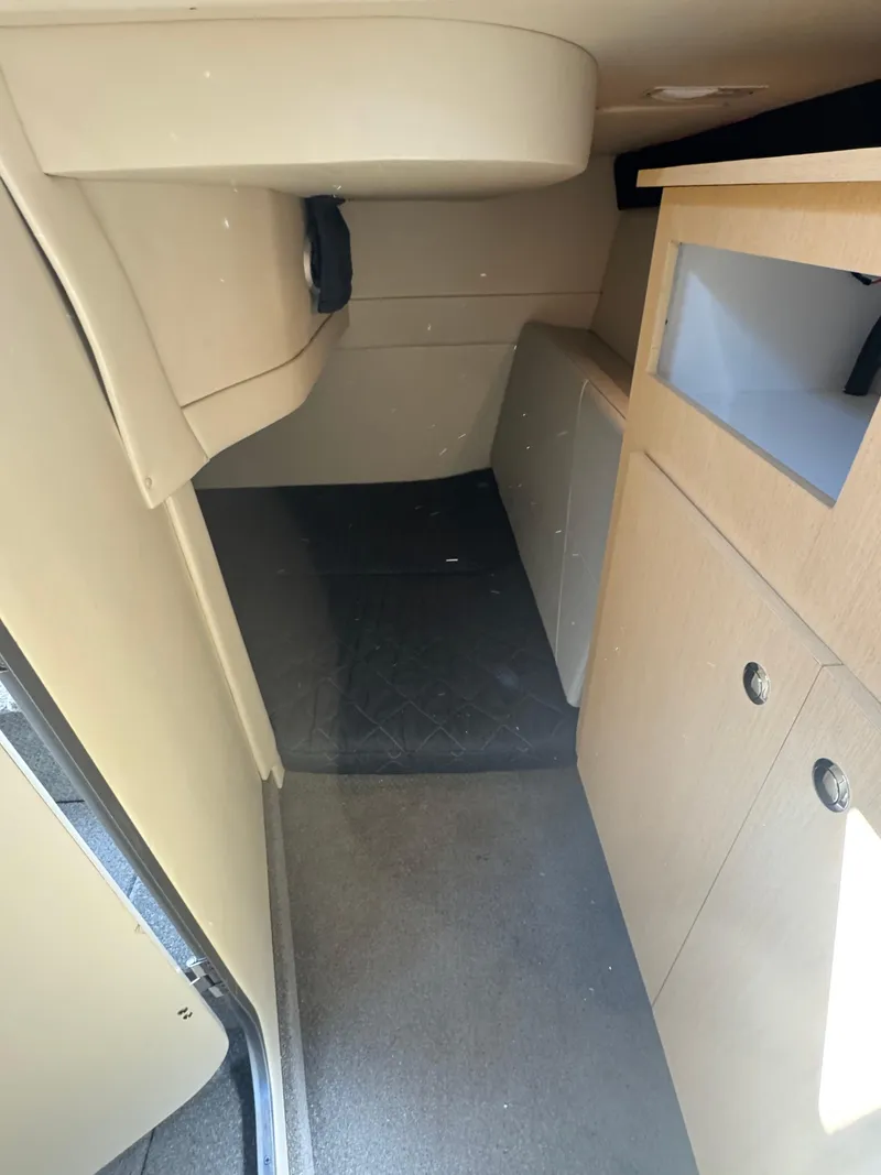 Slide: The Image of Interior cabin of a 2011 Bayliner 285 Cruiser, featuring beige furnishings and compact design. - 14