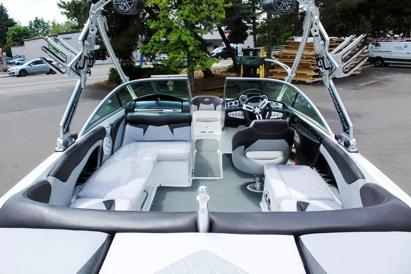 Slide: The Image of 2010 MasterCraft X-15 boat interior with seating and dashboard, parked outdoors. - 21
