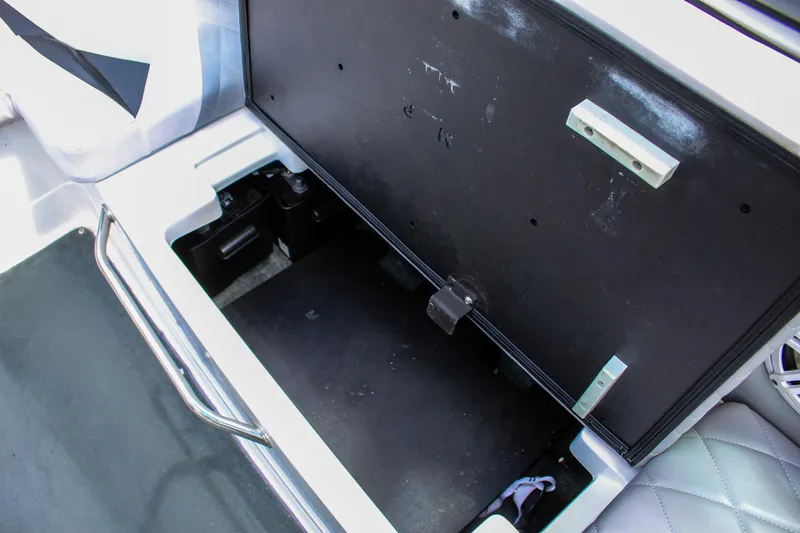 Slide: The Image of 2010 MasterCraft X-15 boat storage compartment, open and empty, with metal handle and cushioned seating. - 33