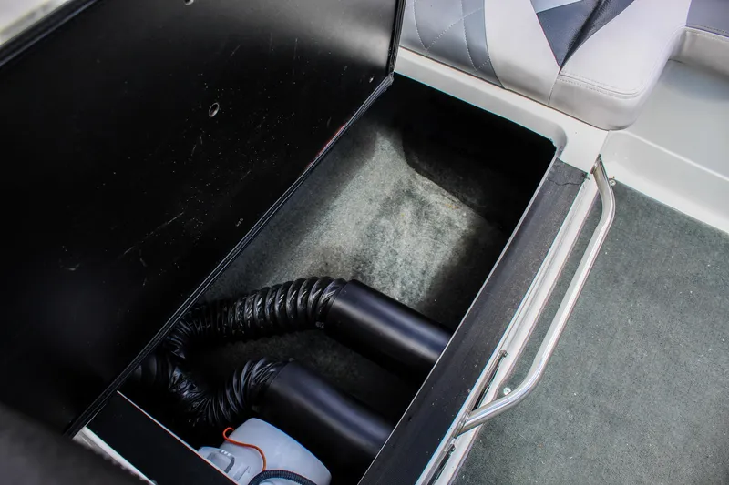 Slide: The Image of Storage compartment in a 2010 MasterCraft X-15 boat, featuring hoses and seating. - 34