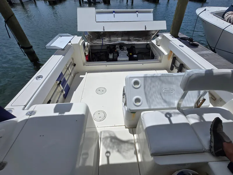 Slide: The Image of 2001 Pursuit 2860 Denali boat interior with open engine compartment at dock. - 10