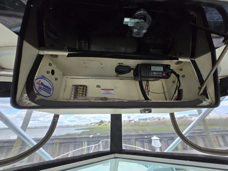 Slide: The Image of 2001 Pursuit 2860 Denali boat dashboard with radio equipment and scenic waterfront view. - 15