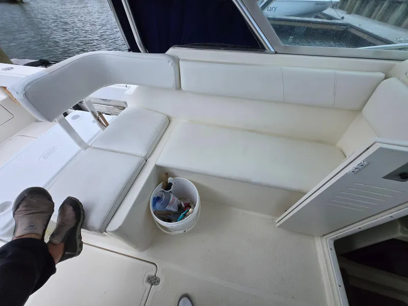 Slide: The Image of 2001 Pursuit 2860 Denali boat interior with white seating and storage compartment. - 17