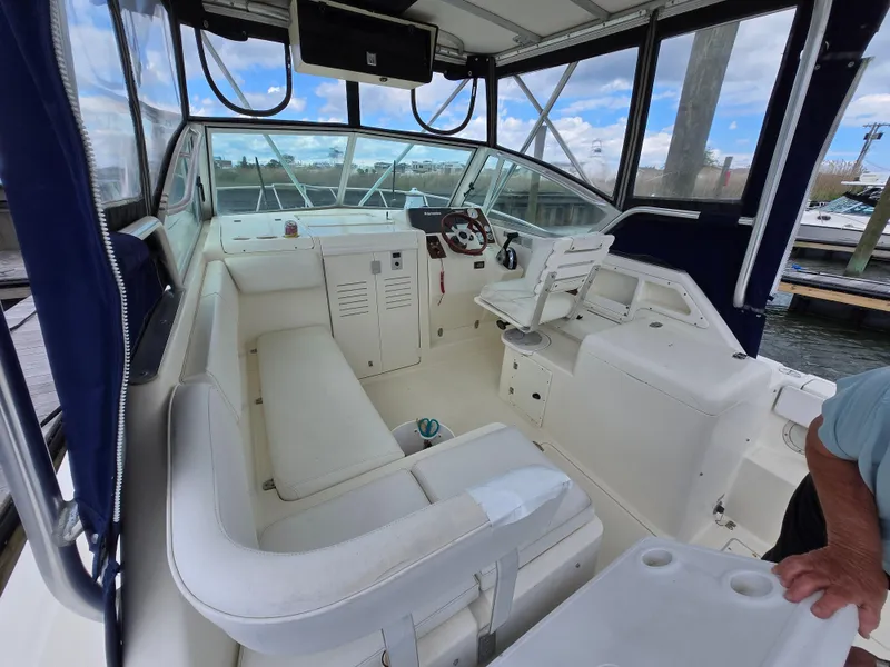 Slide: The Image of 2001 Pursuit 2860 Denali boat interior with white seating and control panel. - 19
