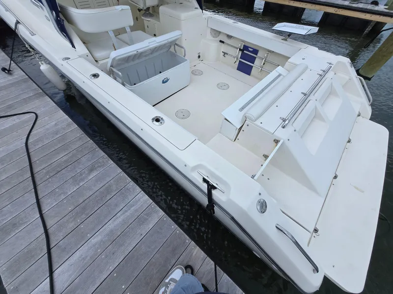 Slide: The Image of 2001 Pursuit 2860 Denali boat docked, featuring spacious deck and seating area. - 22