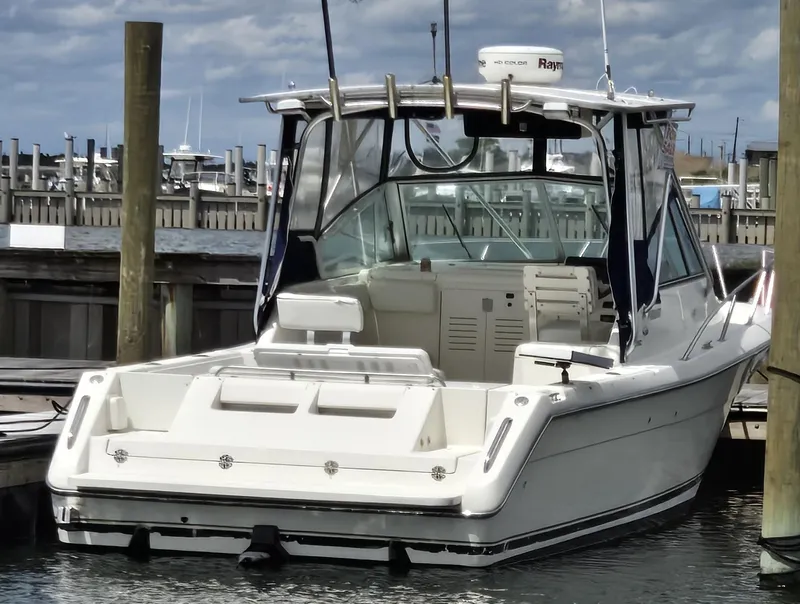 Slide: The Image of 2001 Pursuit 2860 Denali boat docked at marina under cloudy sky. - 6