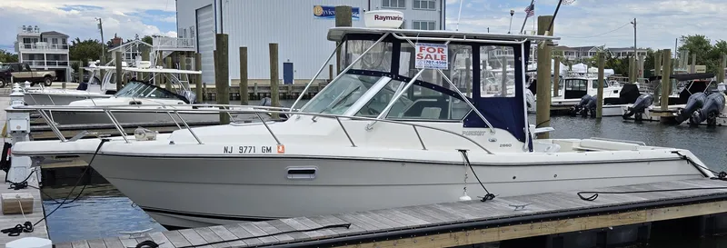 Slide: The Image of 2001 Pursuit 2860 Denali boat docked, for sale sign visible. - 7
