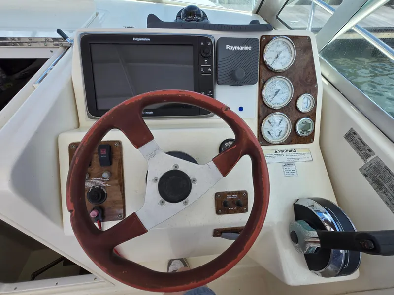 Slide: The Image of 2001 Pursuit 2860 Denali boat dashboard with steering wheel and navigation instruments. - 9