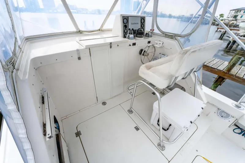 Slide: The Image of 1978 Topaz 28 boat cockpit with white seating and control panel, dockside view. - 13