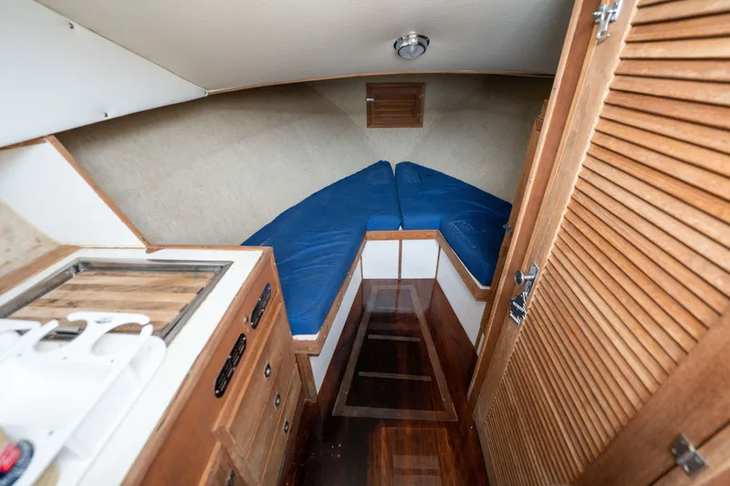 Slide: The Image of Interior of a 1978 Topaz 28 boat with wooden cabinetry and blue cushioned seating. - 19