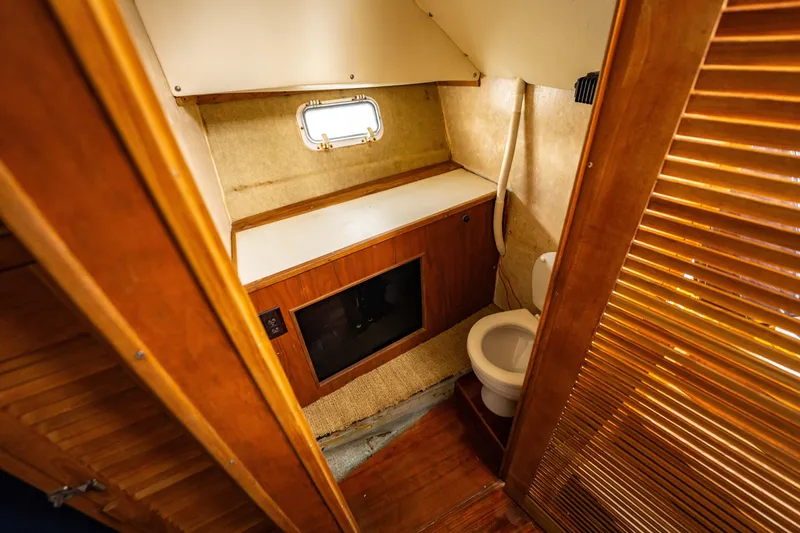 Slide: The Image of 1978 Topaz 28 boat bathroom with wooden cabinetry and small window. - 20