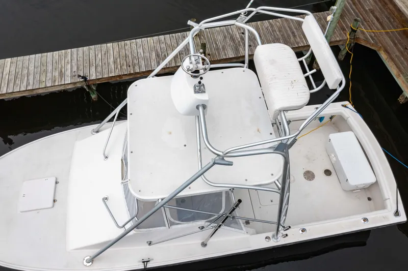 Slide: The Image of 1978 Topaz 28 boat with elevated seating, docked at a wooden pier. - 3