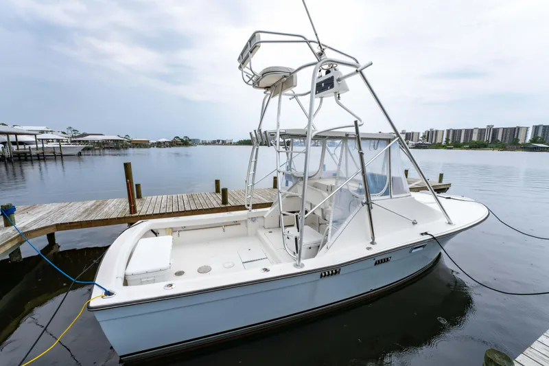 Slide: The Image of 1978 Topaz 28 boat docked by the waterfront, featuring a tall tower and spacious deck. - 9