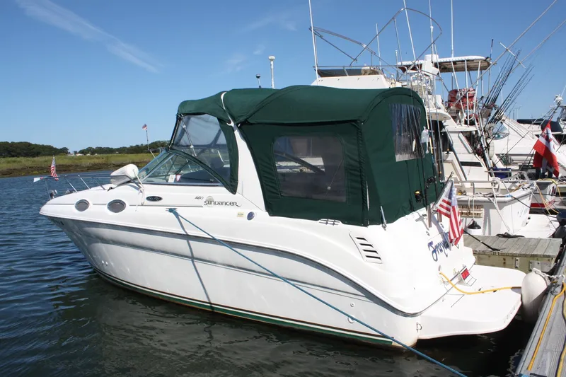 The Image of 2003 Sea Ray 260 Sundancer boat docked with green canopy and American flag. - 0