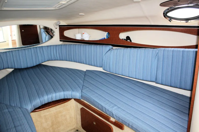 Slide: The Image of 2003 Sea Ray 260 Sundancer cabin with blue upholstery and wooden accents. - 16