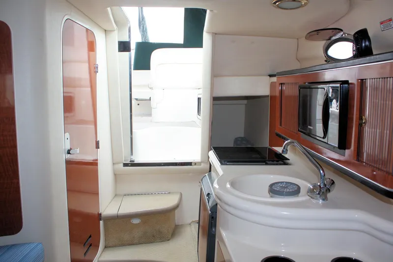 Slide: The Image of Interior of 2003 Sea Ray 260 Sundancer with kitchenette and seating area. - 18