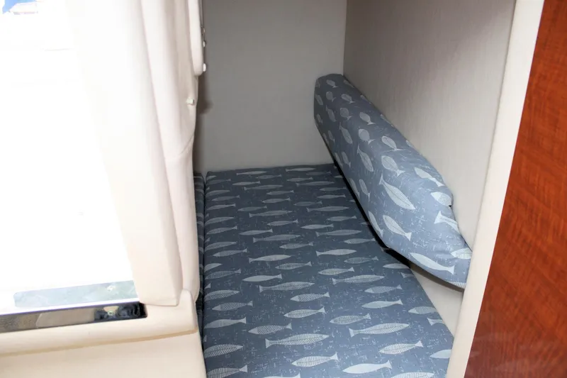 Slide: The Image of 2003 Sea Ray 260 Sundancer cabin with fish-patterned bedding. - 23