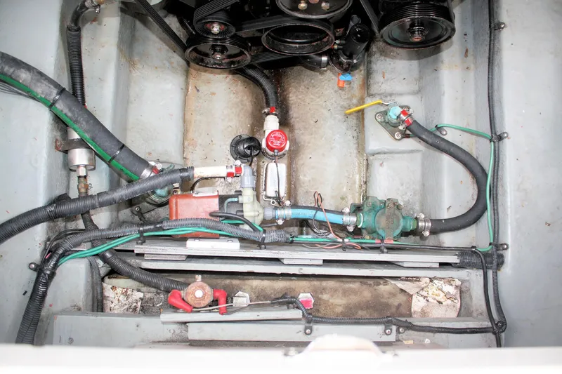 Slide: The Image of Engine compartment of a 2003 Sea Ray 260 Sundancer, showing hoses and mechanical components. - 26