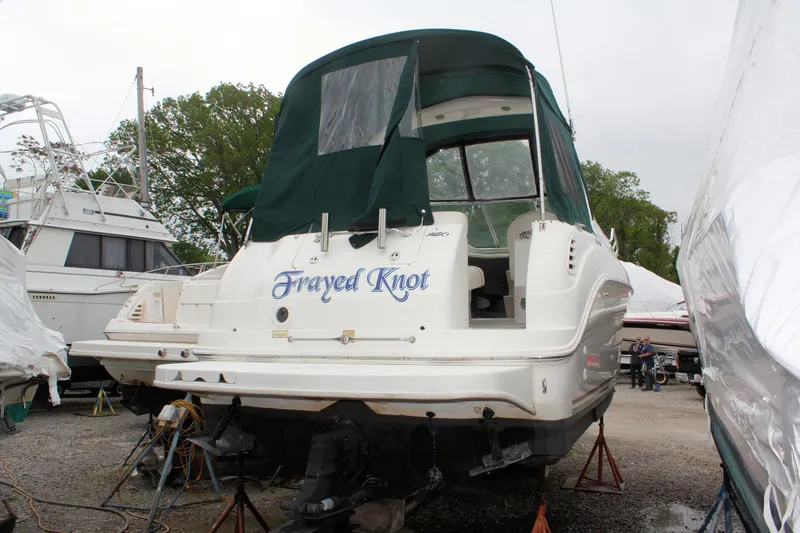 Slide: The Image of 2003 Sea Ray 260 Sundancer boat with green canopy, named "Frayed Knot," on dry dock. - 4