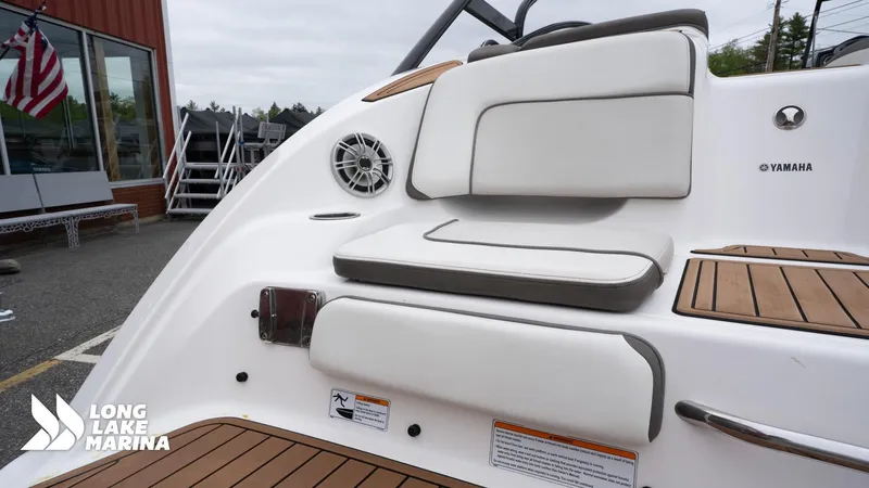 Slide: The Image of 2014 Yamaha Boats 242 Limited S interior with cushioned seating and speaker at Long Lake Marina. - 10