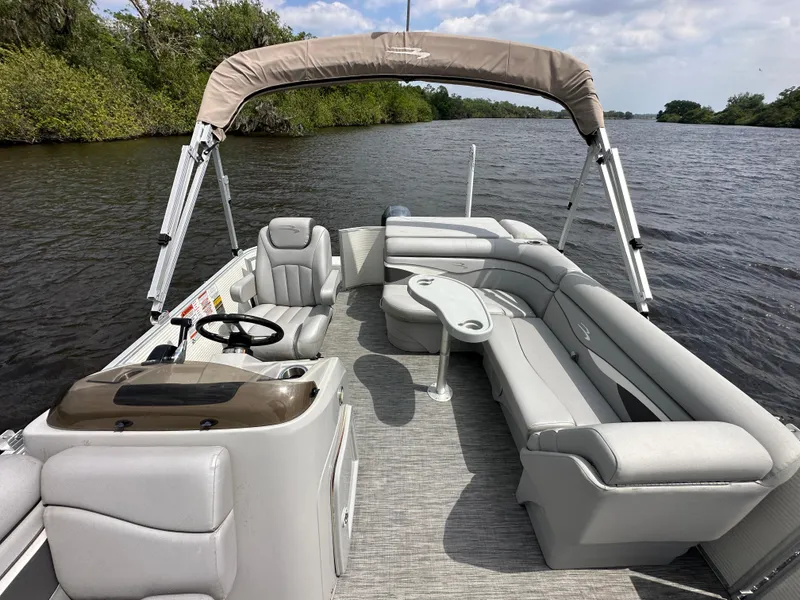 Slide: The Image of 2020 Bennington S 20 SLL pontoon boat on a calm river with lush greenery. - 6
