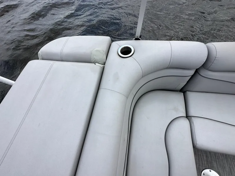 Slide: The Image of Bennington S 20 SLL 2020 boat interior with gray seating and cup holder on water. - 9