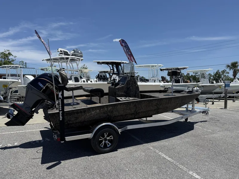Slide: The Image of 2025 Xpress Hyper-Lift H190 Bay Series boat on trailer, parked in a marina. - 2
