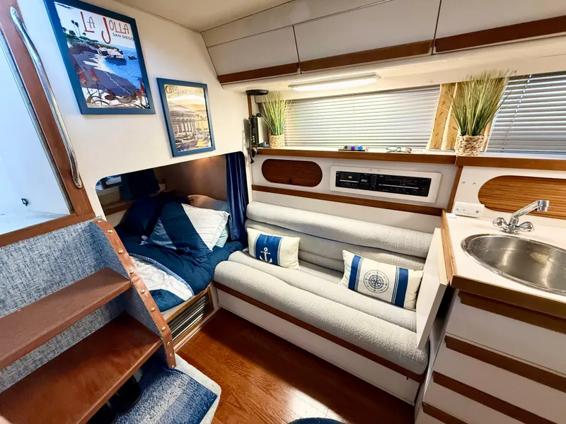 Slide: The Image of 1988 Carver Montego 3257 cabin interior with cozy seating, bed, and compact kitchenette. - 29
