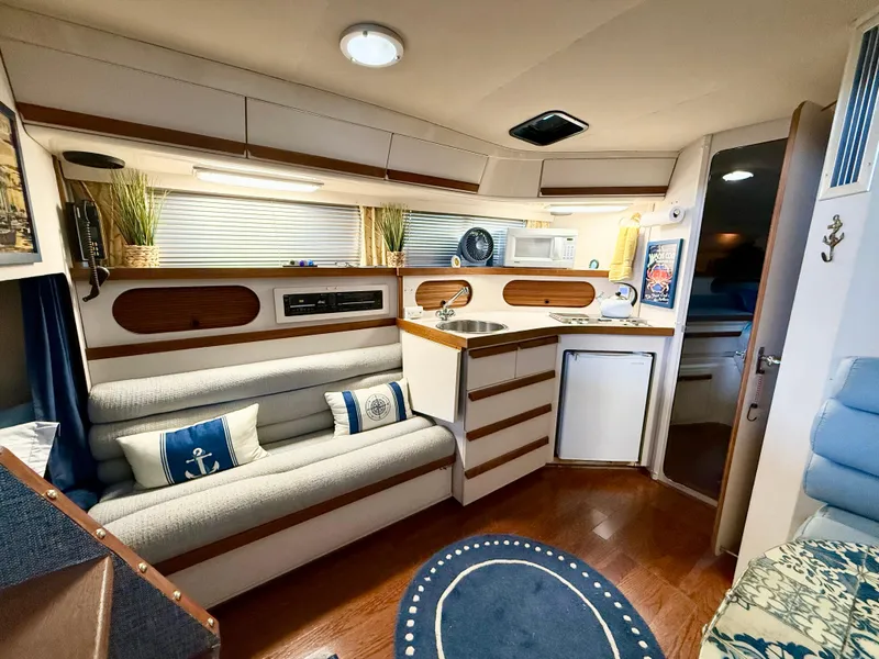 Slide: The Image of Interior of 1988 Carver Montego 3257 boat with cozy seating and kitchenette. - 30